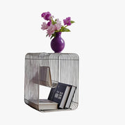 304 stainless steel wire-grid side table with built-in magazine rack, styled with books and a vase