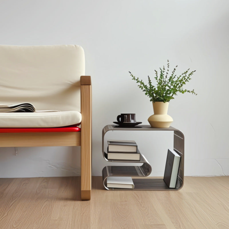 304 stainless steel wire-grid side table beside a chair, styled with books, a cup and a vase